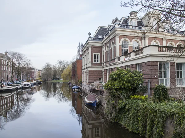 Amsterdam, Nizozemsko na 31 březnu 2016. Typický městský pohled na jaře. Kanál a budovy stavby Xvii a Xviii na nábřežích. — Stock fotografie