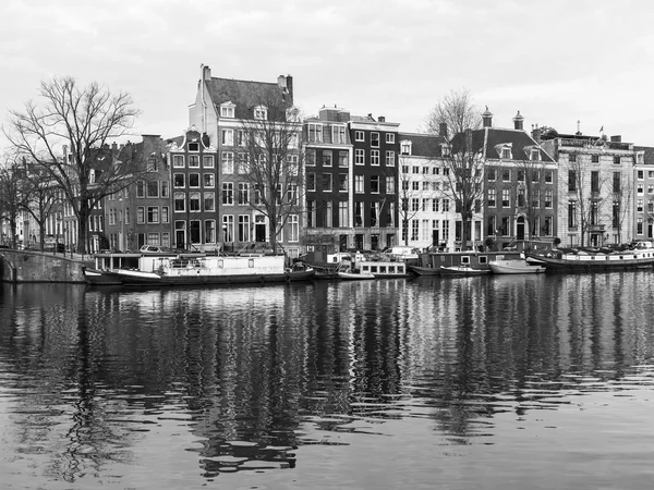 AMSTERDAM, PAYS-BAS, le 31 mars 2016. Vue urbaine typique au printemps. Le canal et les bâtiments de la construction XVII-XVIII sur les remblais. Péniches près de la banque — Photo