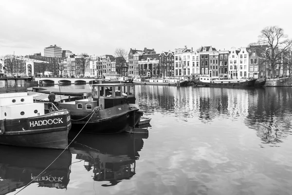 Amsterdam, Nizozemsko na 31 březnu 2016. Typický městský pohled na jaře. Kanál a budovy stavby Xvii a Xviii na náspy. Hausbóty u banky — Stock fotografie