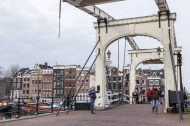 Amsterdam, Hollanda üzerinde 31 Mart 2016. Bahar tipik kent görünümünde. Kanal ve Binalar XVII-XVIII inşaat bentleri üzerinde eski bir hareketli köprü