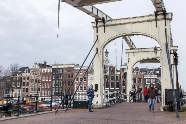 Amsterdam, Niederlande am 31. März 2016. typische Stadtansicht im Frühling. eine alte bewegliche Brücke durch den Kanal und Gebäude der xvii-xviii-Konstruktion auf Böschungen — Stockfoto