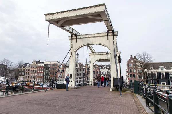 Amsterdam, Nizozemsko na 31 březnu 2016. Typický městský pohled na jaře. Starý pojízdný most přes kanál a budovy stavby Xvii a Xviii na nábřežích — Stock fotografie