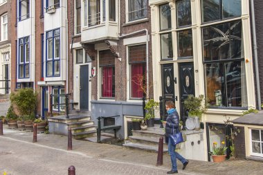 Amsterdam, Hollanda 31 Mart 2016 tarihinde. İlkbaharda tipik şehir manzarası. Şehir caddesinde Xvii-Xviii inşaat binaları