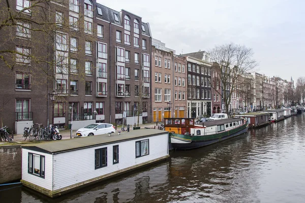 AMSTERDAM, PAÍSES BAJOS 31 DE MARZO DE 2016. Típica vista urbana. El canal y los edificios de la construcción XVII-XVIII sobre terraplenes . — Foto de Stock