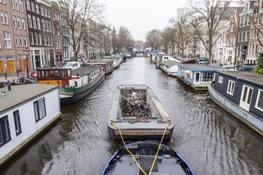 Amsterdam, Hollanda üzerinde 31 Mart 2016. Tipik kentsel görünümü. Kanal dolgu üzerinde geleneksel mimarisinin bir satır. MAVNA batırıldı bisiklet ile bu kanalın üzerinde yüzen dolu. Bankalar yakın yüzen