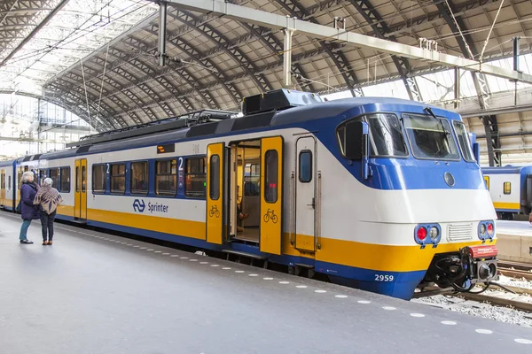 (Inggris) AMSTERDAM, NETHERLANDS on April 1, 2016. Stasiun kereta api. Kereta berkecepatan tinggi modern di peron. Penumpang pergi ke keberangkatan — Stok Foto