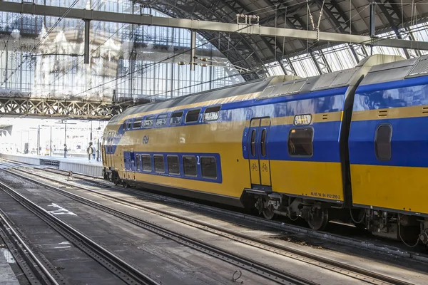 1 kwietnia 2016, Amsterdam, Holandia. Dworzec kolejowy. Nowoczesny pociąg na peronie. Pasażerowie jechać do wyjazdu — Zdjęcie stockowe