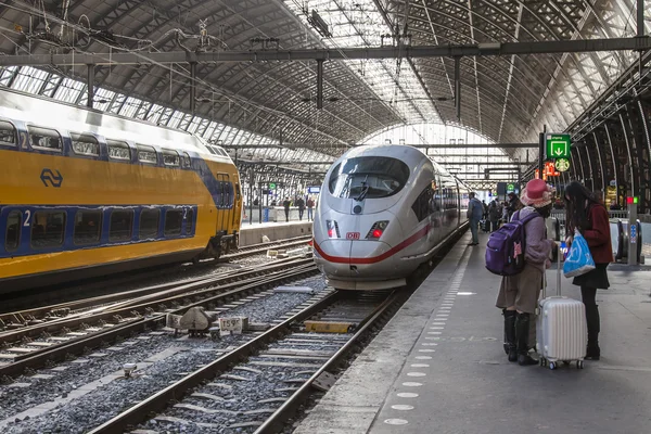 AMESTERDÃO, PAÍSES BAIXOS em 1 de abril de 2016. Estação ferroviária. O moderno trem de alta velocidade na plataforma. Passageiros vão para a partida — Fotografia de Stock