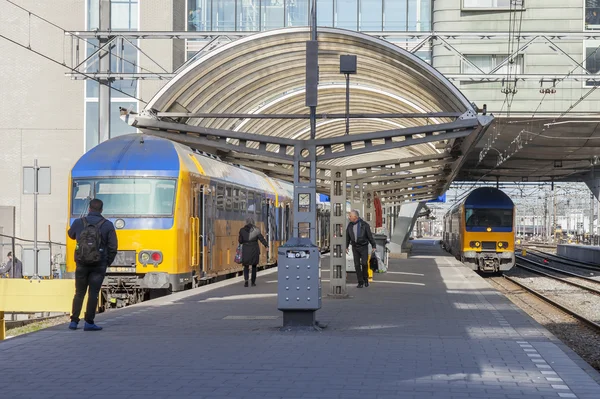 AMSTERDAM, PAÍSES BAJOS 1 DE ABRIL DE 2016. Estación de tren. El moderno tren de alta velocidad en la plataforma. Los pasajeros van a la salida — Foto de Stock