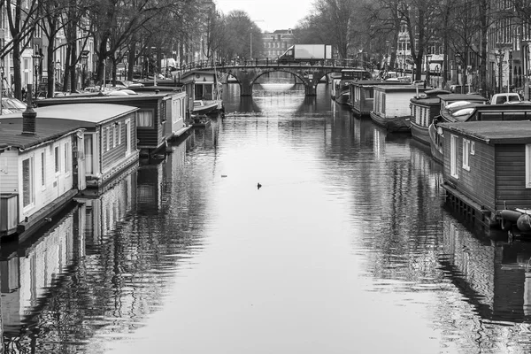 AMESTERDÃO, PAÍSES BAIXOS em 31 de março de 2016. Vista urbana típica. Edifícios da construção XVII-XVIII em aterros. Houseboats perto das margens — Fotografia de Stock