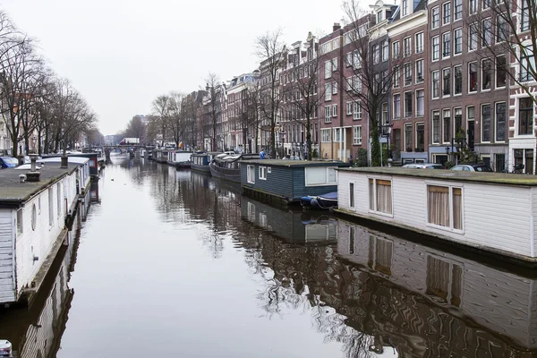 2016 年 3 月 31 日にアムステルダム、オランダ。典型的な都市景観です。堤防の十七-十八建設の建物。川岸に近い屋形船 — ストック写真