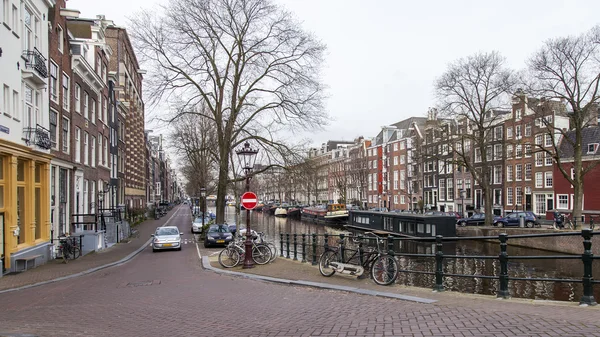 AMSTERDAM, PAÍSES BAJOS 31 DE MARZO DE 2016. Típica vista urbana. El canal y los edificios de la construcción XVII-XVIII sobre terraplenes . — Foto de Stock