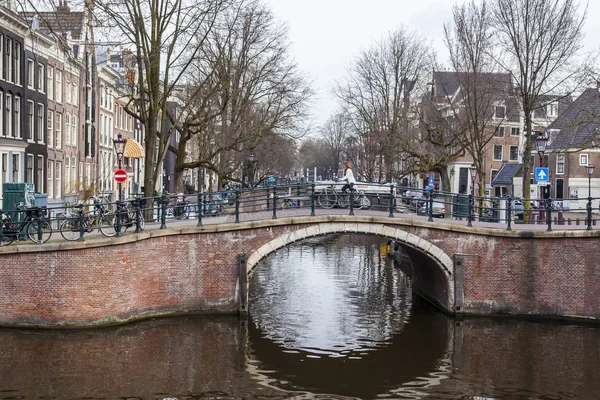 Amsterdam, Nizozemsko na 31 březnu 2016. Typický městský pohled. Obridge přes kanál. Kanál a budovy stavby Xvii a Xviii na nábřežích. — Stock fotografie