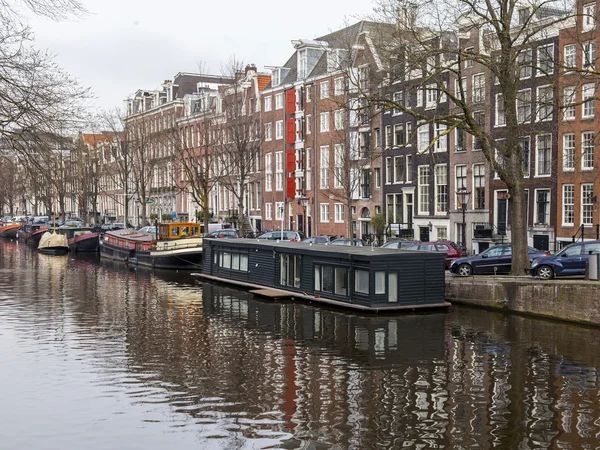 Amsterdam, Nederländerna på den 31 mars, 2016. Typiska urbana vy. Byggnader av Xvii-Xviii byggandet på vallar. Husbåtar nära bankerna — Stockfoto