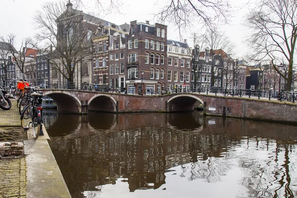 AMSTERDAM, PAÍSES BAJOS 31 DE MARZO DE 2016. Típica vista urbana. Obridge a través del canal. El canal y los edificios de la construcción XVII-XVIII sobre terraplenes . — Foto de Stock