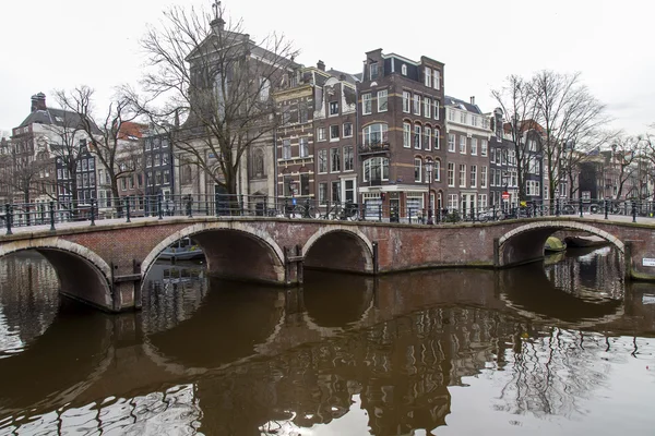 Amsterdam, Nederländerna på den 31 mars, 2016. Typiska urbana vy. Obridge via kanalen. I byggnader av Xvii-Xviii konstruktionen på vallar och kanal. — Stockfoto