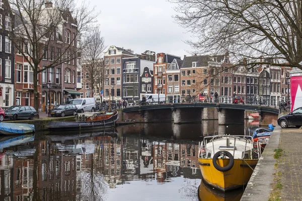 Amsterdam, Nederland op 31 maart 2016. Typisch stedelijke weergave. Obridge via het kanaal. Het kanaal en de gebouwen van de bouw van de Xvii-Xviii op taluds. — Stockfoto