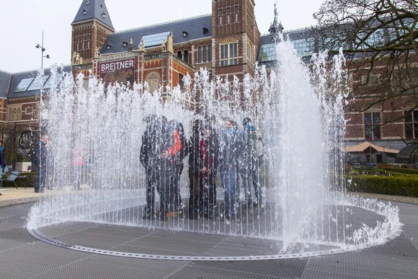 AMSTERDAM, NETHERLANDS on March 31, 2016. Вид на город. Фонтан на музейной площади. Туристы хорошо проводят время . — стоковое фото