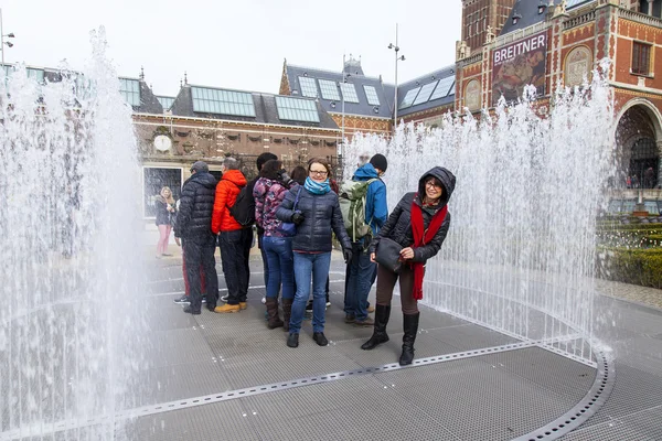 Amsterdam, Nederländerna den 31 mars, 2016. Stadsutsikt. Fontänen på Museumplein. Turister har en bra tid. — Stockfoto