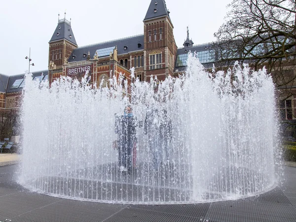 AMSTERDAM, NETHERLANDS on March 31, 2016. Вид на город. Фонтан на музейной площади. Туристы хорошо проводят время . — стоковое фото