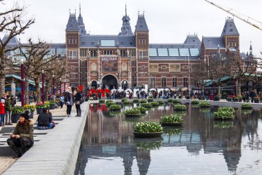   Amsterdam, Hollanda üzerinde 31 Mart 2016. Müze Meydanı'na. Rijksmuseum. Turistler yazıt yakınındaki iyi vakit ben Amsterdam. Lale ile Çiçeklik tarafından dekore edilmiş çeşme