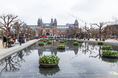  Amsterdam, Hollanda üzerinde 31 Mart 2016. Müze Meydanı'na. Rijksmuseum. Turistler yazıt yakınındaki iyi vakit ben Amsterdam. Lale ile Çiçeklik tarafından dekore edilmiş çeşme