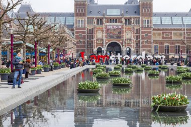   Amsterdam, Hollanda üzerinde 31 Mart 2016. Müze Meydanı'na. Rijksmuseum. Turistler yazıt yakınındaki iyi vakit ben Amsterdam. Lale ile Çiçeklik tarafından dekore edilmiş çeşme