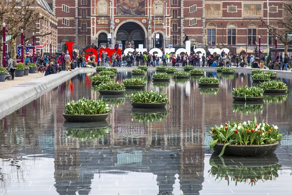 Amsterdam, Niederlande am 31. März 2016. Museumsplatz. rijksmuseum. Touristen haben eine gute Zeit in der Nähe der Inschrift i amsterdam. der Brunnen mit Blumentöpfen und Tulpen — Stockfoto