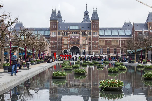 AMSTERDAM, PAYS-BAS, le 31 mars 2016. Museum Square. Rijksmuseum. Les touristes passent un bon moment près de l'inscription I AMsterdam. La fontaine décorée de pots de fleurs avec des tulipes — Photo
