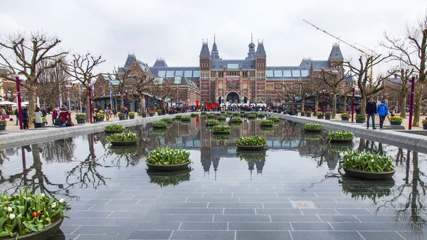   Amsterdam, Hollanda üzerinde 31 Mart 2016. Müze Meydanı'na. Rijksmuseum. Turistler yazıt yakınındaki iyi vakit ben Amsterdam. Lale ile Çiçeklik tarafından dekore edilmiş çeşme