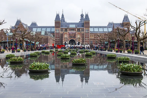 AMSTERDAM, PAYS-BAS, le 31 mars 2016. Museum Square. Rijksmuseum. Les touristes passent un bon moment près de l'inscription I AMsterdam. La fontaine décorée de pots de fleurs avec des tulipes — Photo