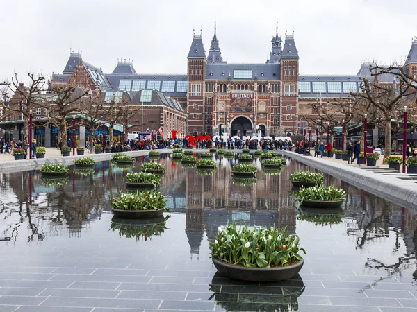 AMSTERDAM, PAYS-BAS, le 31 mars 2016. Museum Square. Rijksmuseum. Les touristes passent un bon moment près de l'inscription I AMsterdam. La fontaine décorée de pots de fleurs avec des tulipes — Photo