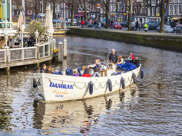 AMSTERDAM, NETHERLANDS on MARCH 31, 2016. Typical urban view. The channel and buildings of the XVII-XVIII construction on embankments. The walking ship floats on the channel — Stock Photo, Image