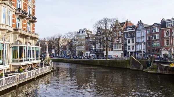 AMSTERDAM, PAÍSES BAJOS 31 DE MARZO DE 2016. Típica vista urbana. El canal y los edificios de la construcción XVII-XVIII sobre terraplenes . — Foto de Stock