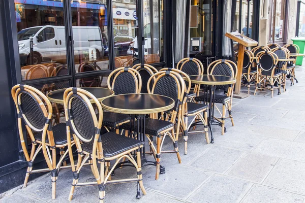 PARIGI, FRANCIA, il 12 LUGLIO 2016 Tavolini di tipico caffè parigino sul marciapiede vicino a una grande finestra . — Foto Stock