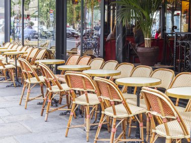 Paris, Fransa, üzerinde 12 Temmuz 2016. Tipik Paris cafe yakınındaki büyük pencere kaldırımda küçük tablolar.