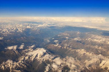 Göksel manzara. Beyaz bulutlar ve massif manzarasına güneşin uçan uçak penceresinden yaktı.