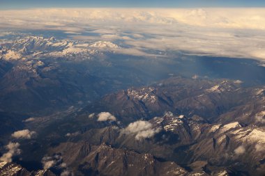 Göksel manzara. Beyaz bulutlar ve massif manzarasına güneşin uçan uçak penceresinden yaktı.