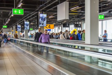 Amsterdam, Hollanda üzerinde 5 Temmuz 2016. Schiphol Havalimanı'nda travelator yolcuları 