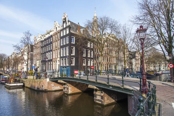 Amsterdam, Nederländerna den 31 mars, 2016. Typisk stadsutsikt. Kanalen och byggnaderna i XVII-XVIII konstruktion på vallar. den gamla bron via kanalen. — Stockfoto