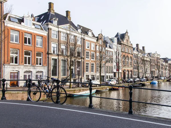 AMSTERDAM, PAYS-BAS, le 31 mars 2016. Vue urbaine typique. Le canal et les bâtiments de la construction XVII-XVIII sur les remblais. le vieux pont par le canal . — Photo