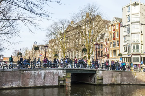 AMSTERDAM, PAYS-BAS, le 31 mars 2016. Vue urbaine typique. Le canal et les bâtiments de la construction XVII-XVIII sur les remblais. le vieux pont par le canal . — Photo