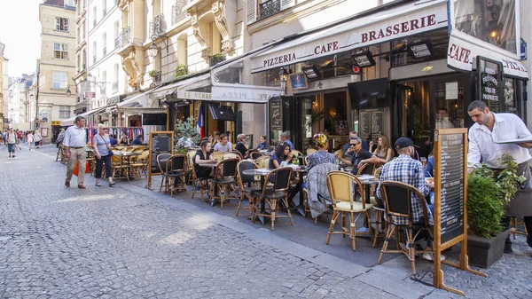 Paris, Frankreich, am 5. Juli 2016. Typische Pariser Straße am Morgen. Menschen ruhen sich aus und essen im Café unter freiem Himmel. — Stockfoto