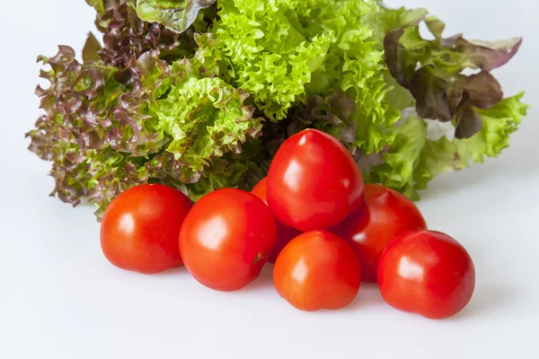 Ripe red tomatoes and lettuce leaves — Stock Photo, Image