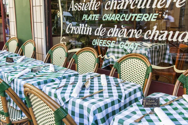 Paris, Frankrike, på 7 juli 2016. Typisk parisisk gata på morgonen. Lilla bordlägger av café under bar himmel. — Stockfoto