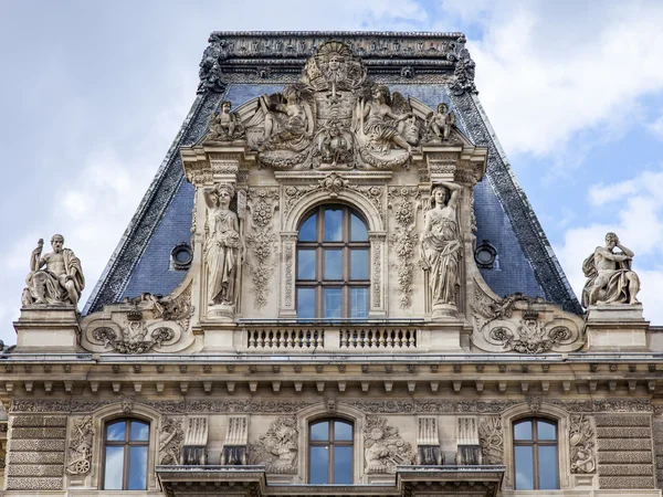 Paris, Frankrike, på 11 juli 2016. Arkitektoniska fragment av en av fasader av museet Louvren (fr. Musée du Louvre). Denna byggnad - det gamla kungliga palatset (Palais du Louvre) — Stockfoto