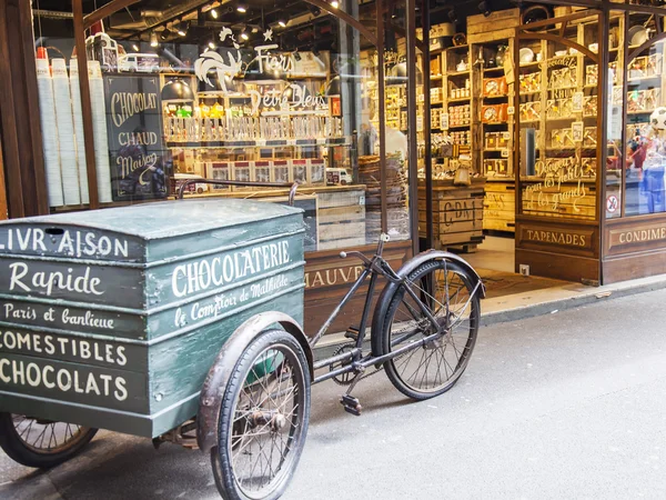 PARIS, FRANCE, on JULY 7, 2016. A show-window of shop of chocolate and the vintage cart for delivery of orders — Stock Photo, Image