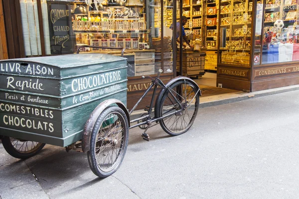 París, Francia, 7 de julio de 2016. Un escaparate de tienda de chocolate y el carro de la vendimia para la entrega de pedidos — Foto de Stock