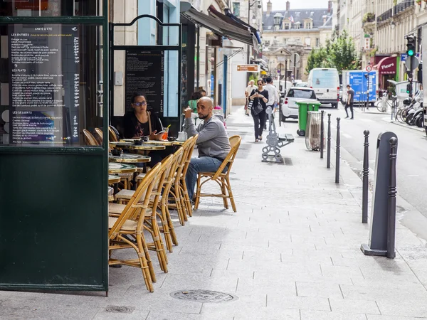 Paris, Frankreich, am 7. Juli 2016. Typische Pariser Straße am Morgen. Menschen essen und erholen sich im Café unter freiem Himmel. — Stockfoto