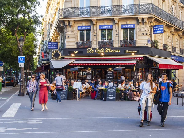 Париж, Франция, 8 июля 2016 г. Типичный вид на город. Люди идут по улице и хорошо проводят время в уличном кафе. — стоковое фото